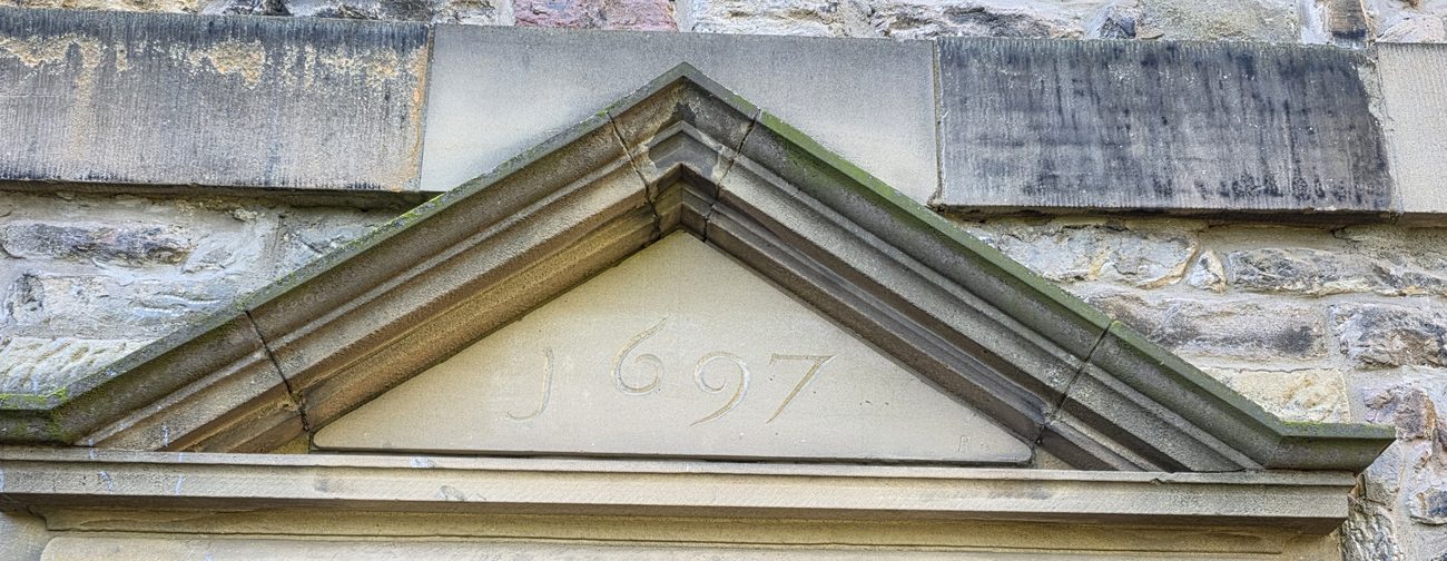 Carved stone pediment dated 1697 above a doorway of the Old Surgeons' Hall, Edinburgh